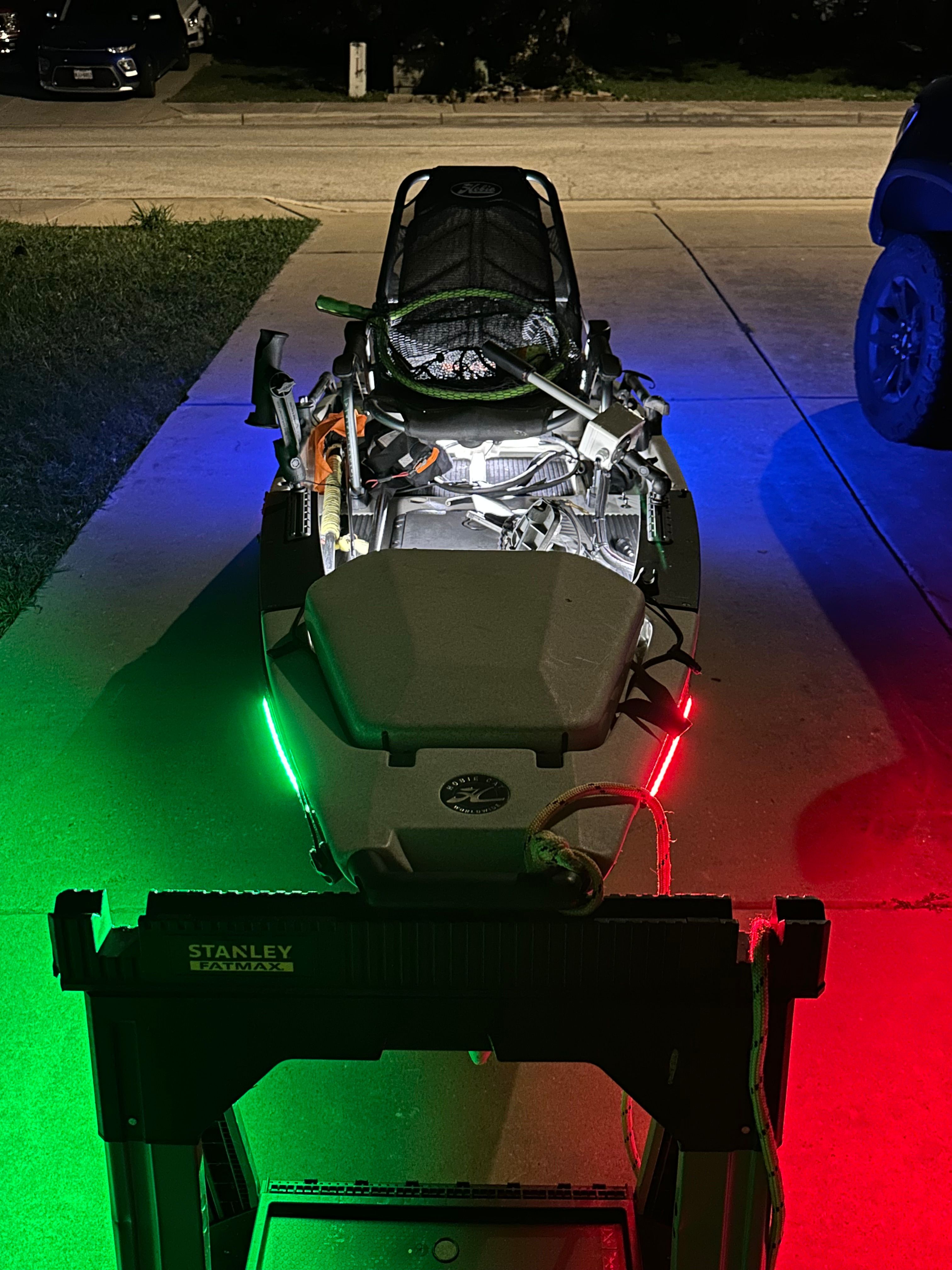 Hobie PRO ANGLER 2011 Hobie PRO ANGLER kayak with colorful LED lights on a driveway at night.