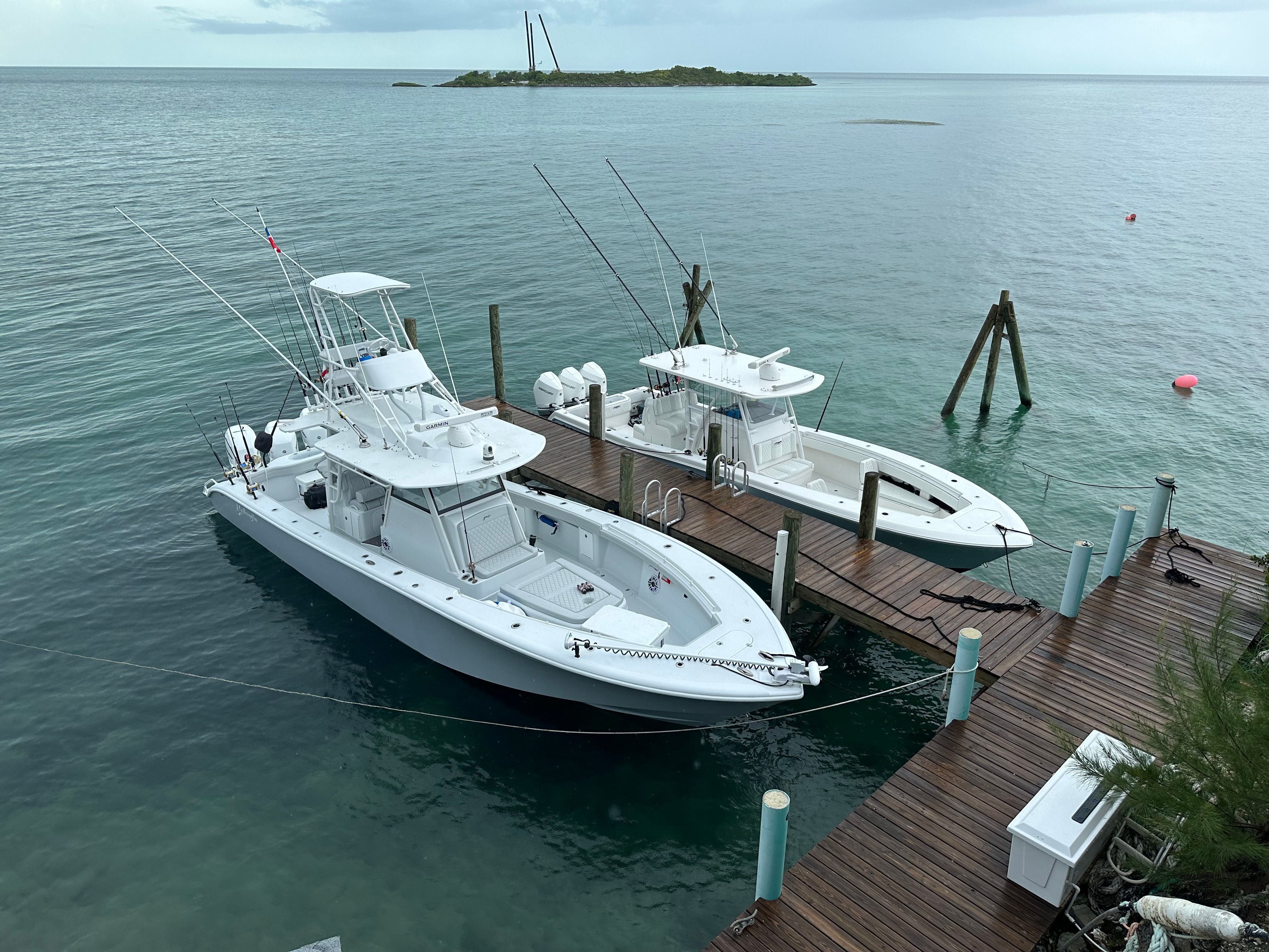Yellowfin 39 Offshore 2023 Yellowfin 39 Offshore boats docked on a wooden pier, ocean view.