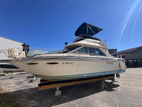 Sea Ray 265 Sedan Bridge 1988 Sea Ray 265 Sedan Bridge boat on dry dock under clear blue sky.