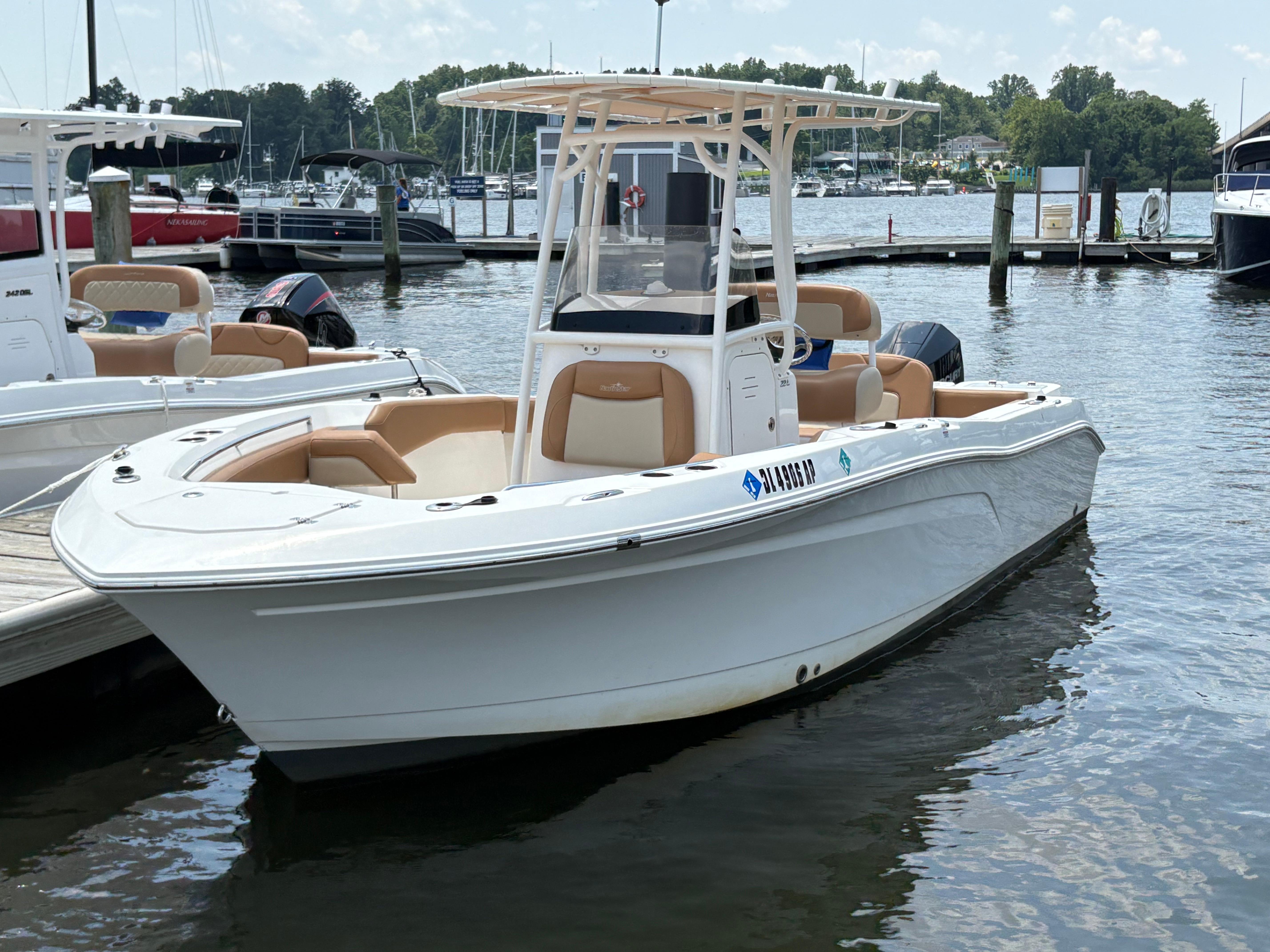 NauticStar 22L 2023 NauticStar 22L boat docked at marina, featuring sleek design and spacious seating.