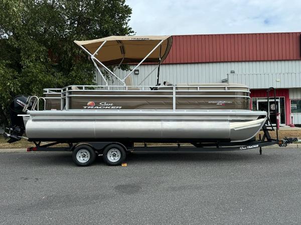 Sun Tracker SportFish 22 XP3 2025 Sun Tracker SportFish 22 XP3 pontoon boat on trailer, parked outdoors.
