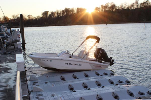 Boston Whaler 130 Super Sport 2021 Boston Whaler 130 Super Sport docked at sunset on a serene lake.