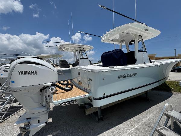 Regulator 28 2025 Regulator 28 boat with Yamaha engine, docked under a clear blue sky.