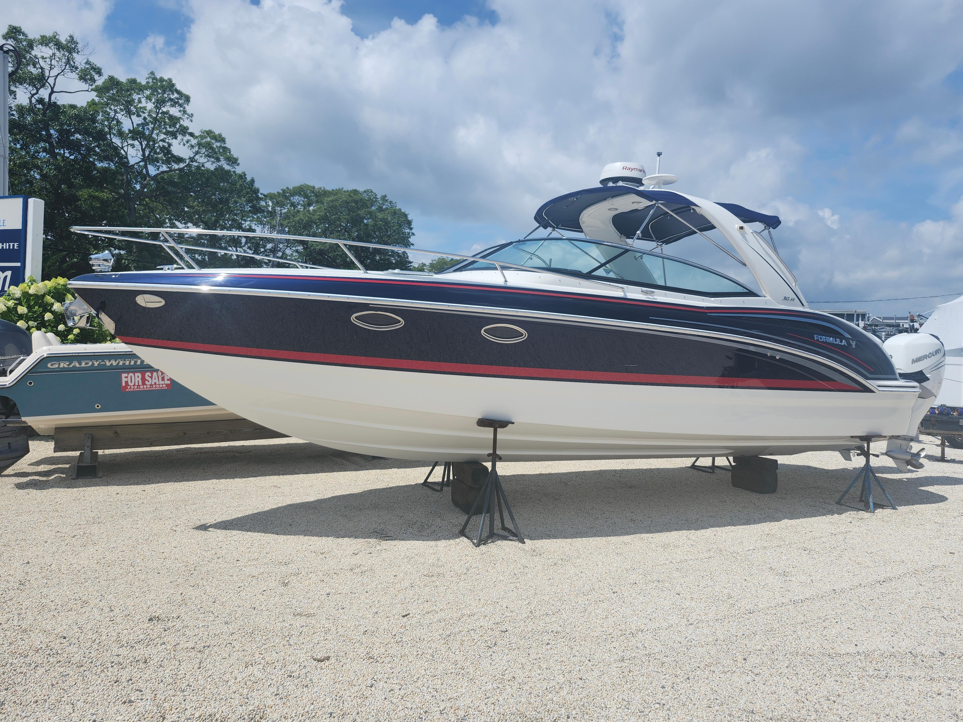 Formula 310 Sun Sport 2020 Formula 310 Sun Sport boat displayed outdoors on stands under a cloudy sky.
