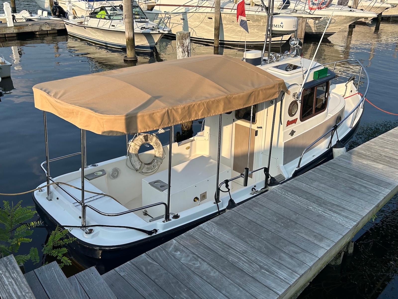 Ranger Tugs R21-EC 2008 Ranger Tugs R21-EC docked, featuring a tan canopy and classic design.