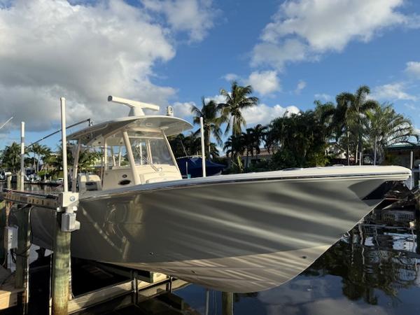 Cobia 320 CC 2018 Cobia 320 CC boat docked under a partly cloudy sky.