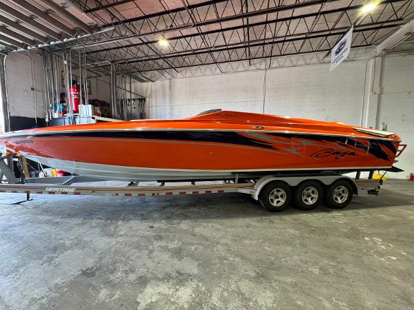 Baja 35 Outlaw 2007 Baja 35 Outlaw speedboat in vibrant orange, parked on a trailer in a warehouse.