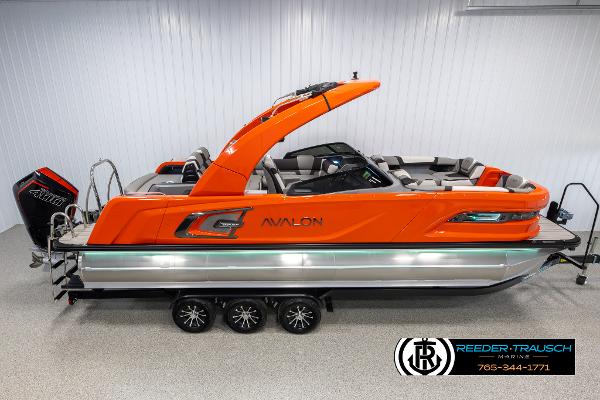 Avalon Excalibur VRB 2024 Avalon Excalibur VRB pontoon boat in vibrant orange, displayed indoors.