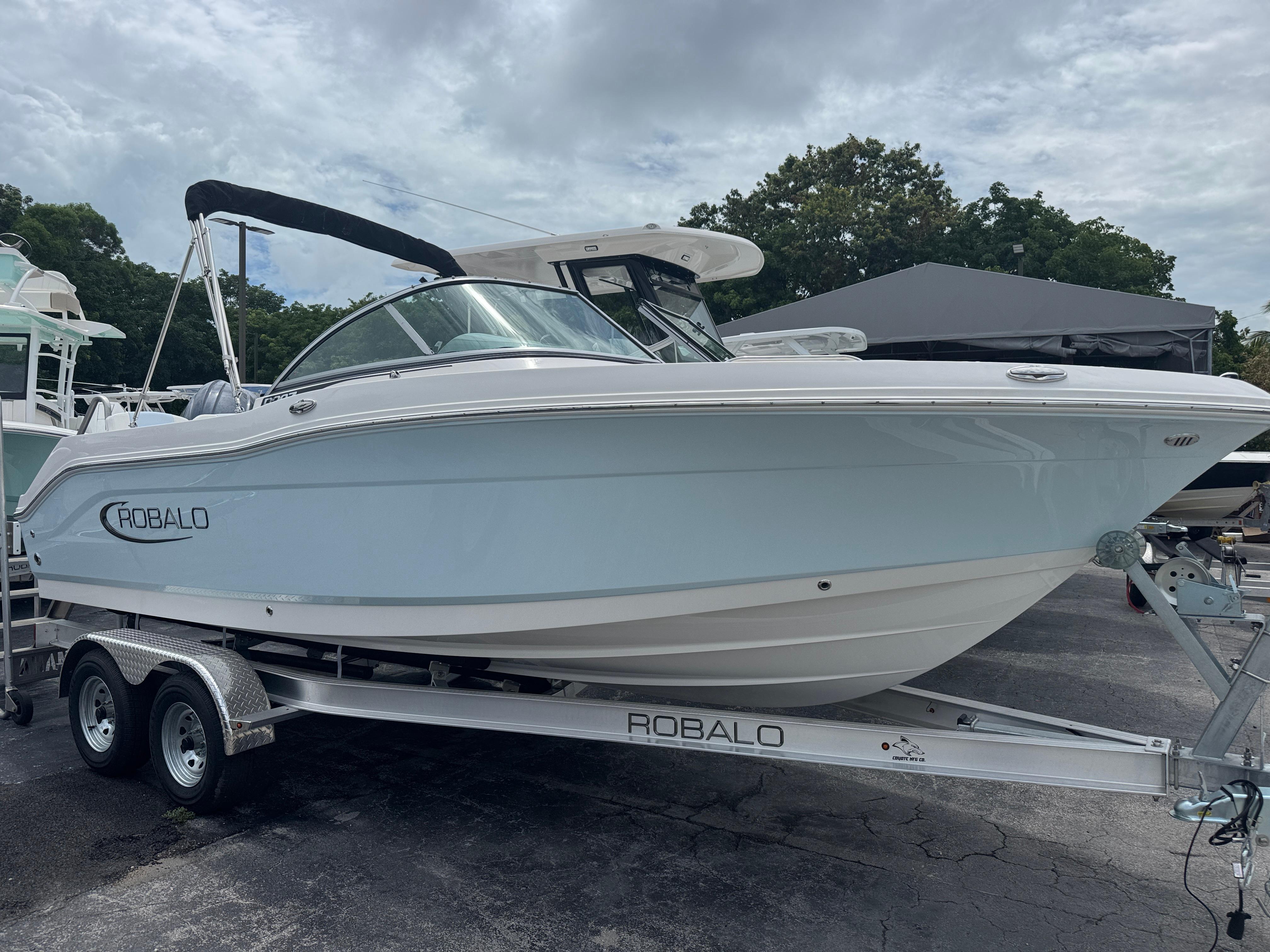 Robalo R207 Dual Console 2025 Robalo R207 Dual Console boat on trailer, parked outdoors under cloudy sky.