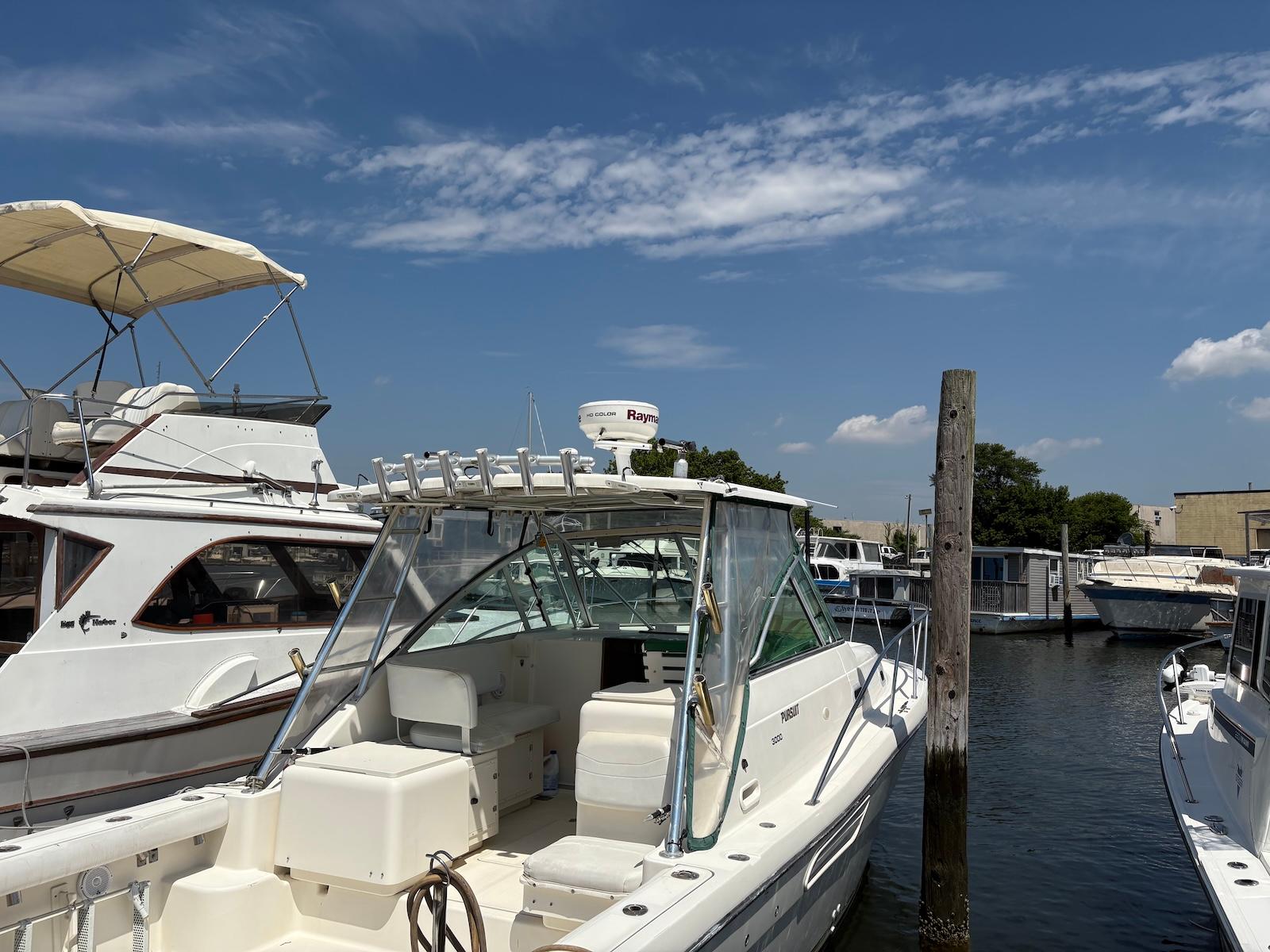 Pursuit 3000 Express 2002 Pursuit 3000 Express boat docked at marina under clear blue sky.