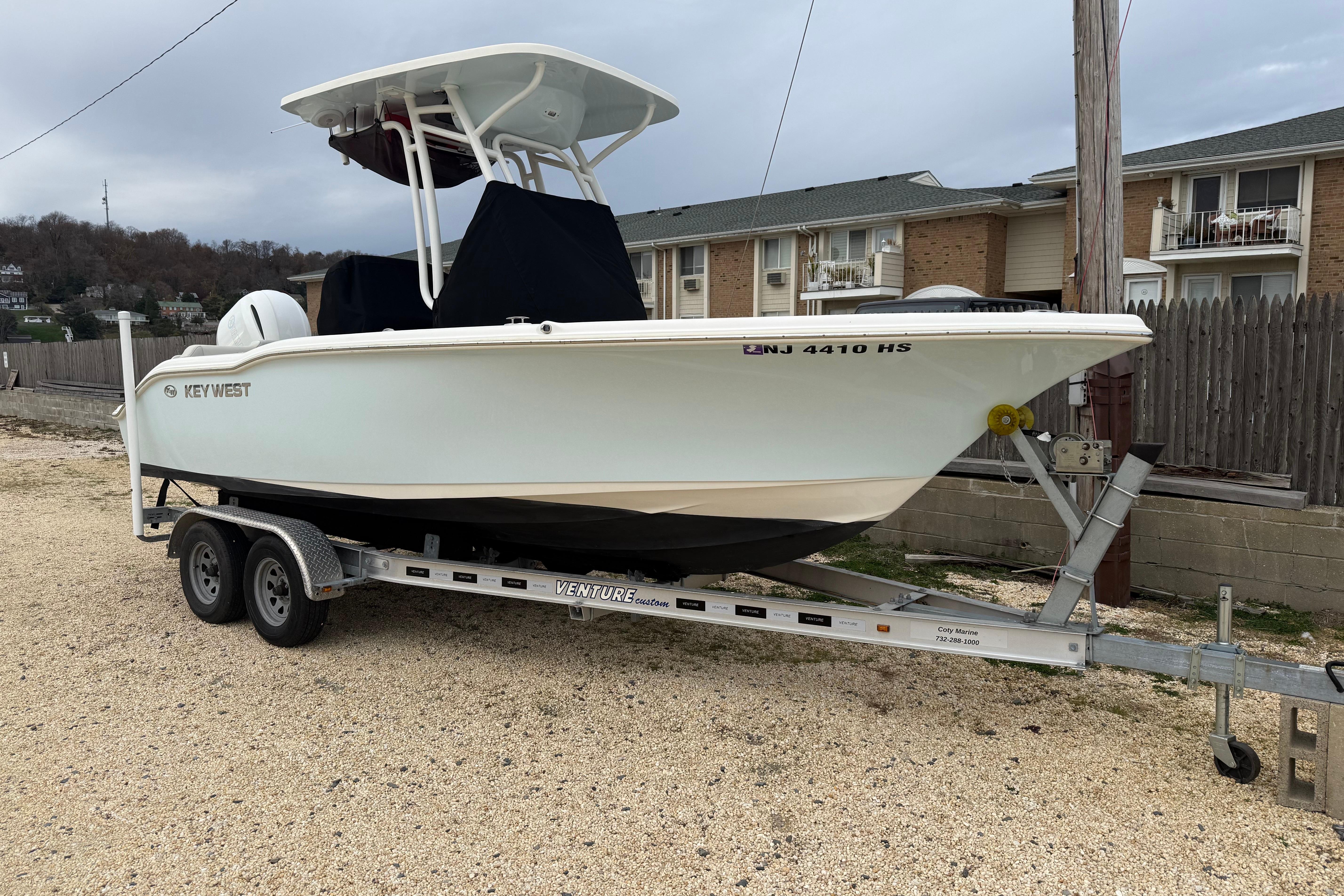 Key West 219 FS 2023 Key West 219 FS boat on trailer, parked outdoors near residential area.