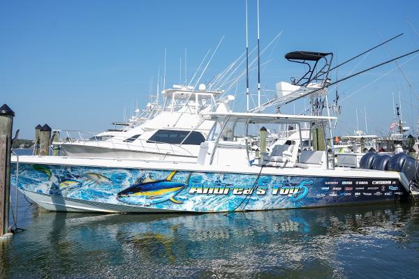 Contender 39 ST 2023 Contender 39 ST fishing boat docked, featuring vibrant marine graphics and multiple outboard engines.
