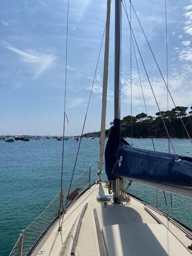 Beneteau First 22 Beneteau First 22 sailboat on calm sea, 1983 model, with clear sky and distant shoreline.
