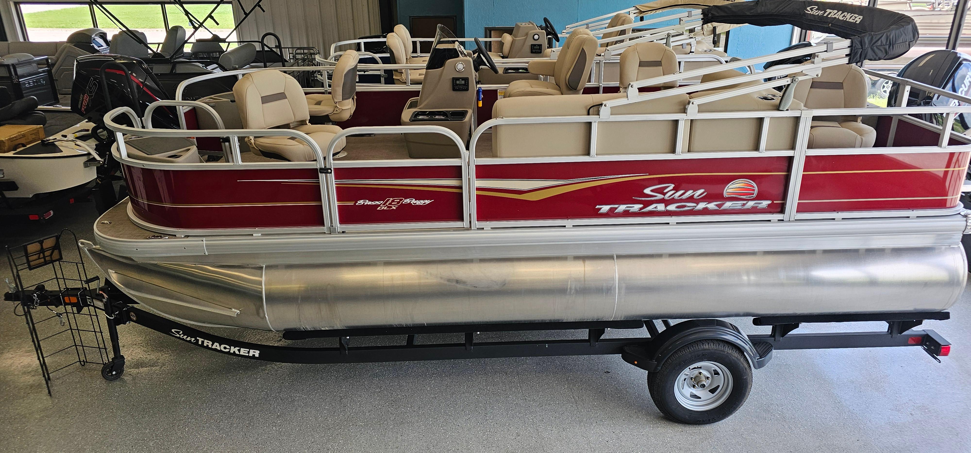 Sun Tracker Bass Buggy 18 DLX 2025 Sun Tracker Bass Buggy 18 DLX pontoon boat in showroom, featuring red and beige design.