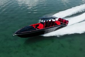 Midnight Express 39S Cuddy 2002 Midnight Express 39S Cuddy boat speeding on clear water, featuring sleek black and red design.
