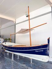 Llaut 32P Vintage 1999 Llaut 32P boat displayed indoors with wooden mast and blue hull.