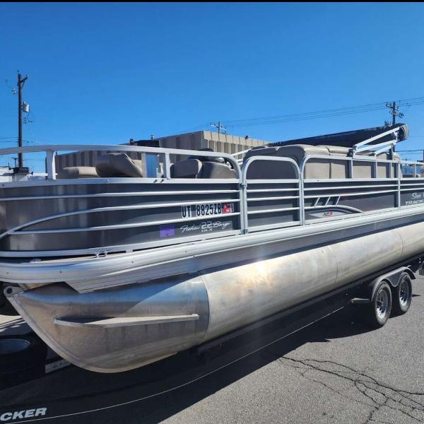 Trader 22xp3 2020 Trader 22xp3 pontoon boat on trailer, parked outdoors under clear blue sky.