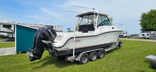 Boston Whaler 285 Conquest 2016 Boston Whaler 285 Conquest boat on a trailer, parked on grass.