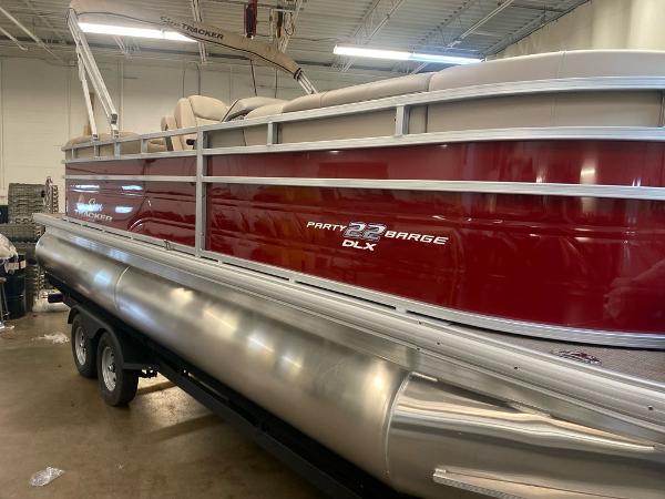 Sun Tracker Party Barge 22 RF DLX 2025 Sun Tracker Party Barge 22 RF DLX pontoon boat in a showroom.