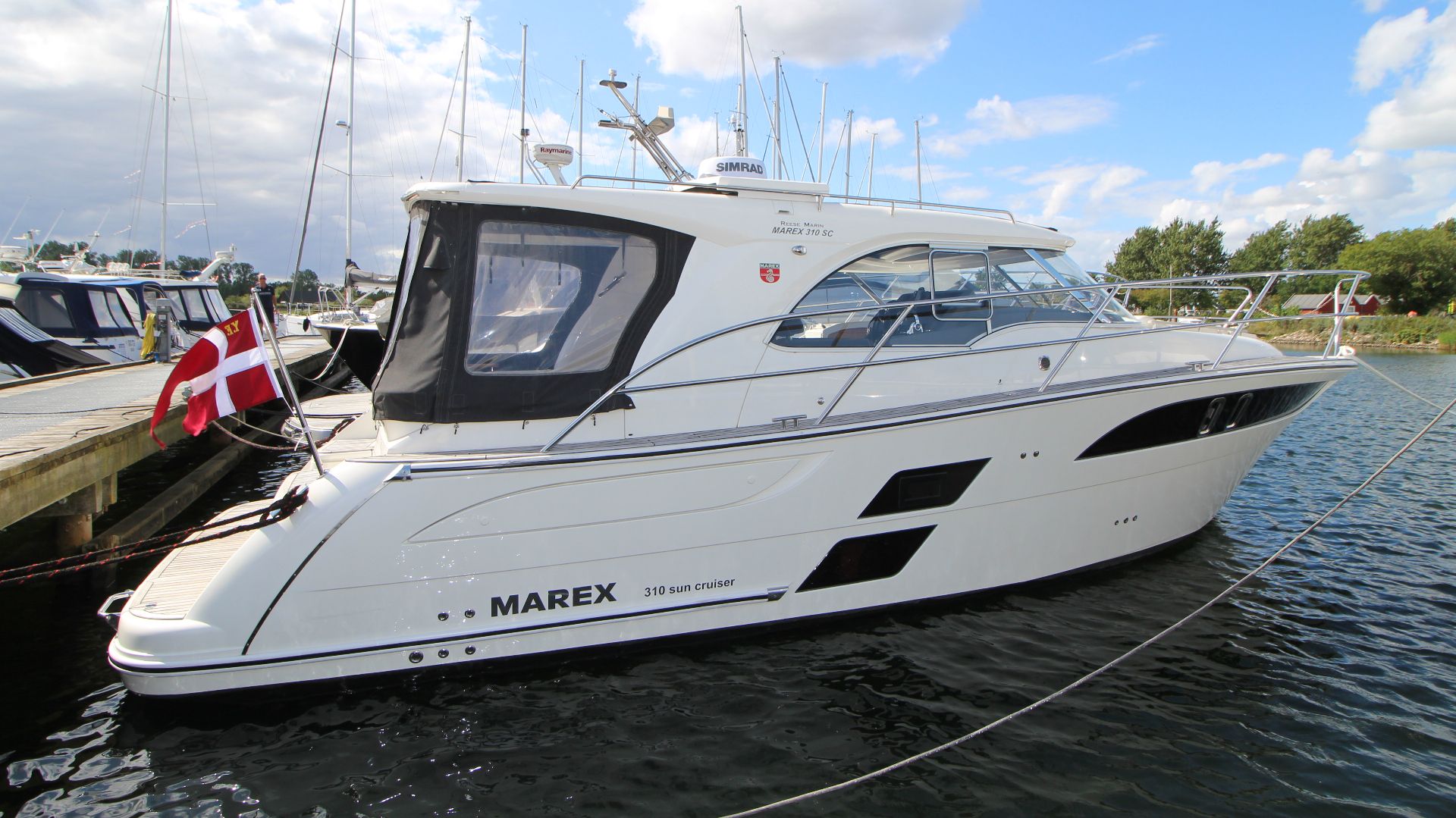Marex 310 Sun Cruiser 2019 Marex 310 Sun Cruiser yacht docked, featuring sleek design and Danish flag.