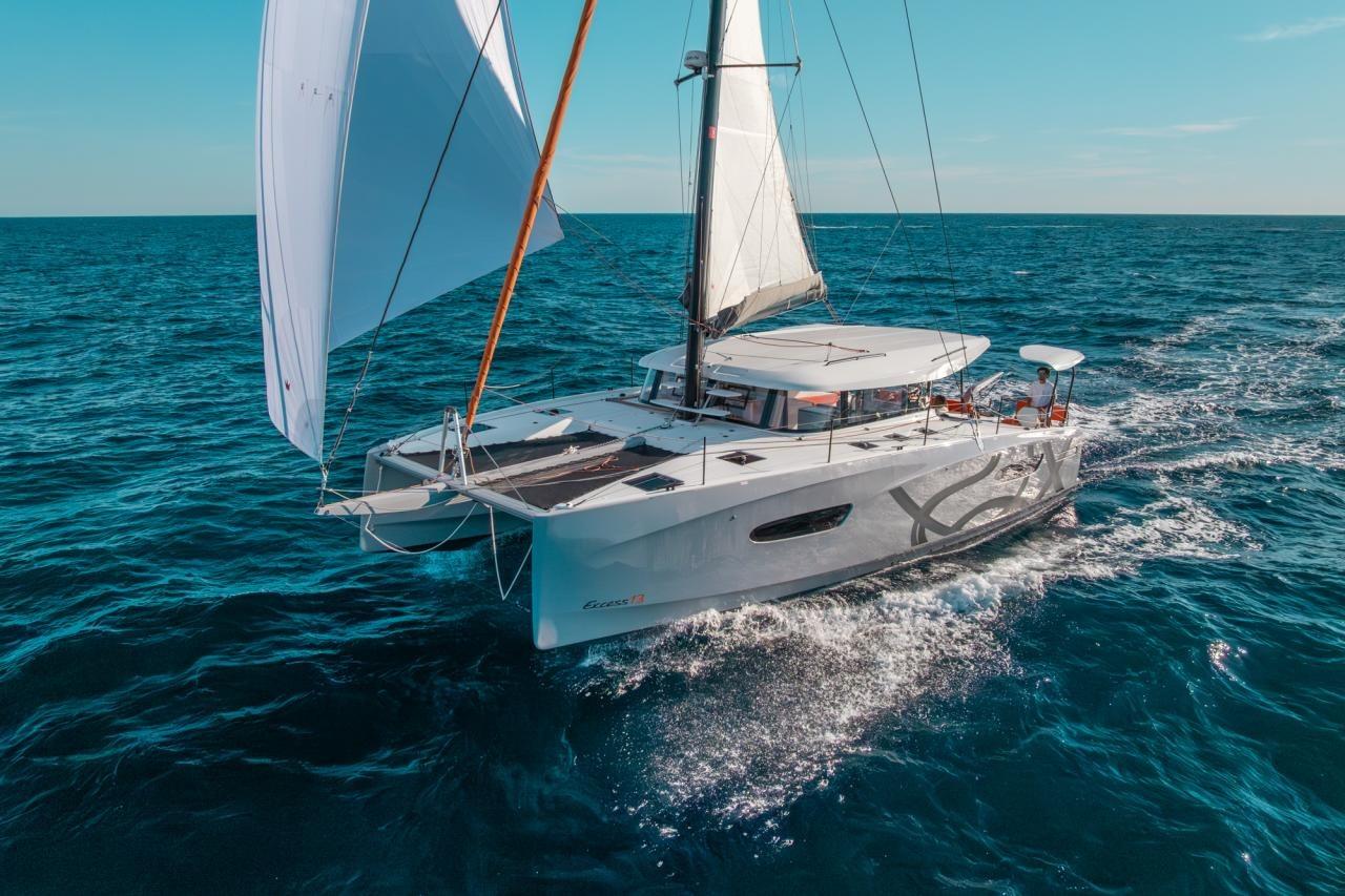 Excess Excess 13 2025 Excess 13 catamaran sailing on open sea under clear blue sky.