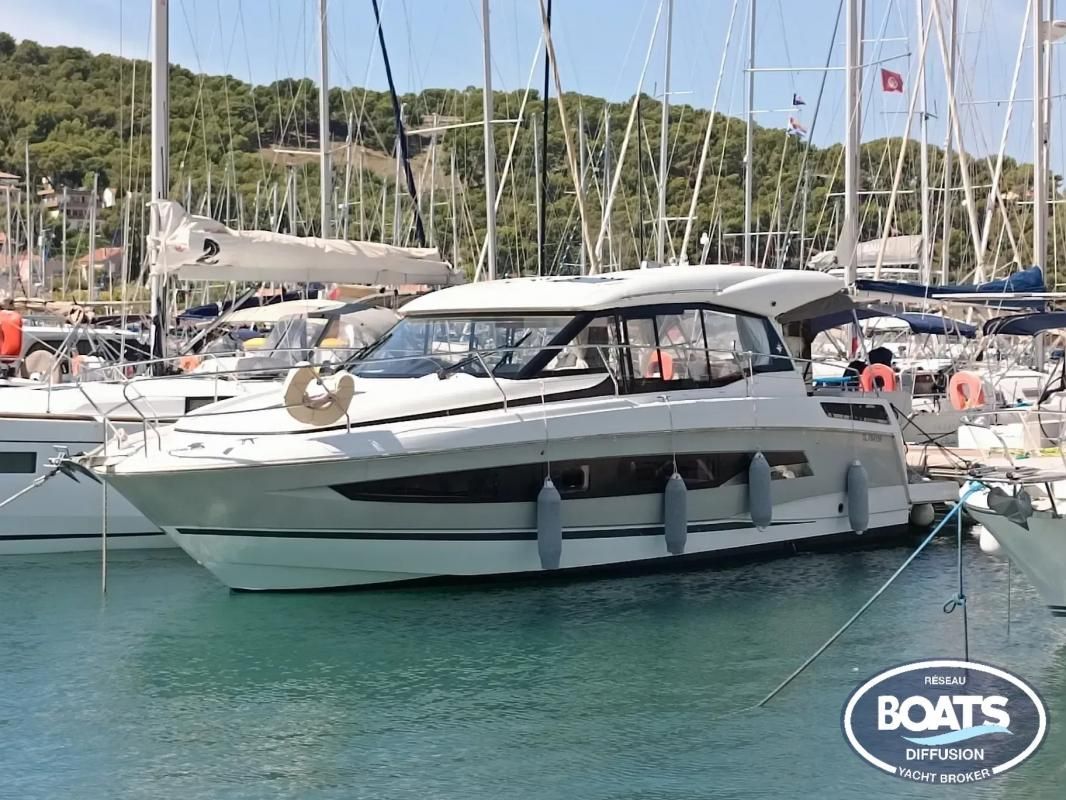Jeanneau NC37 2019 Jeanneau NC37 yacht docked in a marina, surrounded by sailboats.