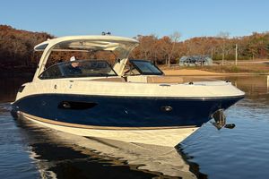 Sea Ray 350 SLX 2016 Sea Ray 350 SLX boat cruising on a calm lake near a wooded shoreline.