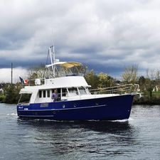 Beneteau Swift Trawler 42 2004 Beneteau Swift Trawler 42 cruising on a river under cloudy skies.