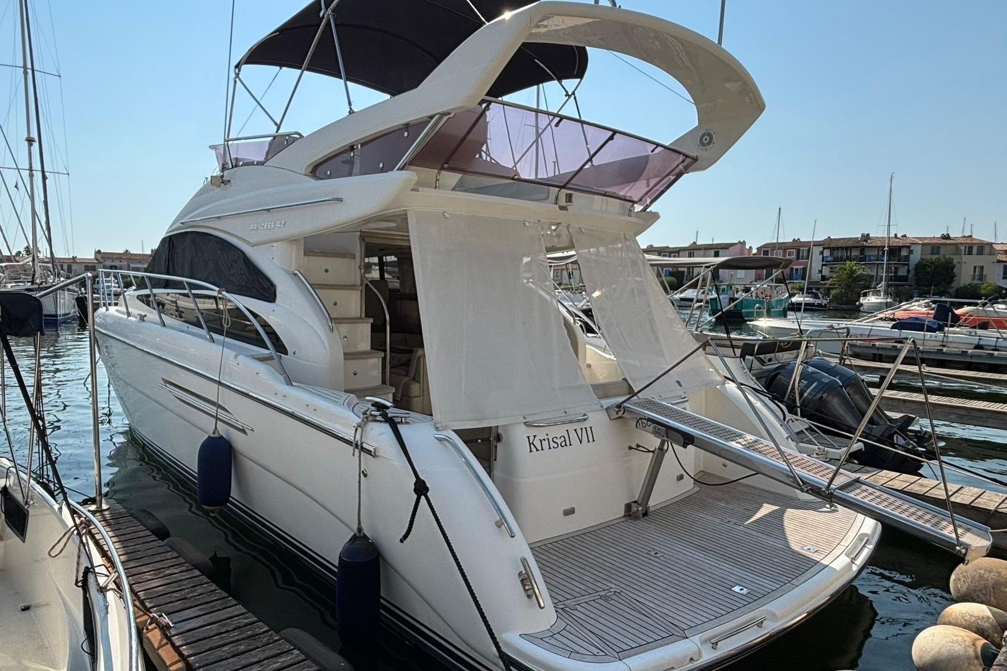 Princess 42 Luxury Princess 42 yacht, 2013 model, docked at a marina under clear skies.