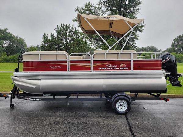 Sun Tracker Party Barge 18 DLX 2024 Sun Tracker Party Barge 18 DLX pontoon boat on trailer.