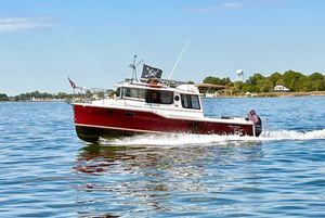 Ranger Tugs R-25 2020 Ranger Tugs R-25 cruising on a calm lake with scenic shoreline.