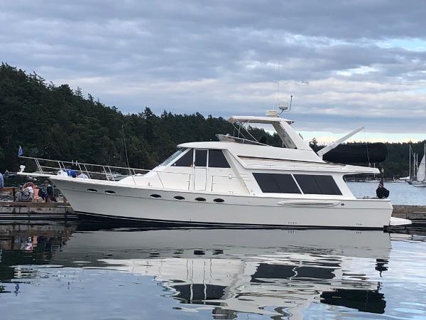 Meridian 490 Pilothouse 2003 Meridian 490 Pilothouse yacht docked on calm water, surrounded by trees.