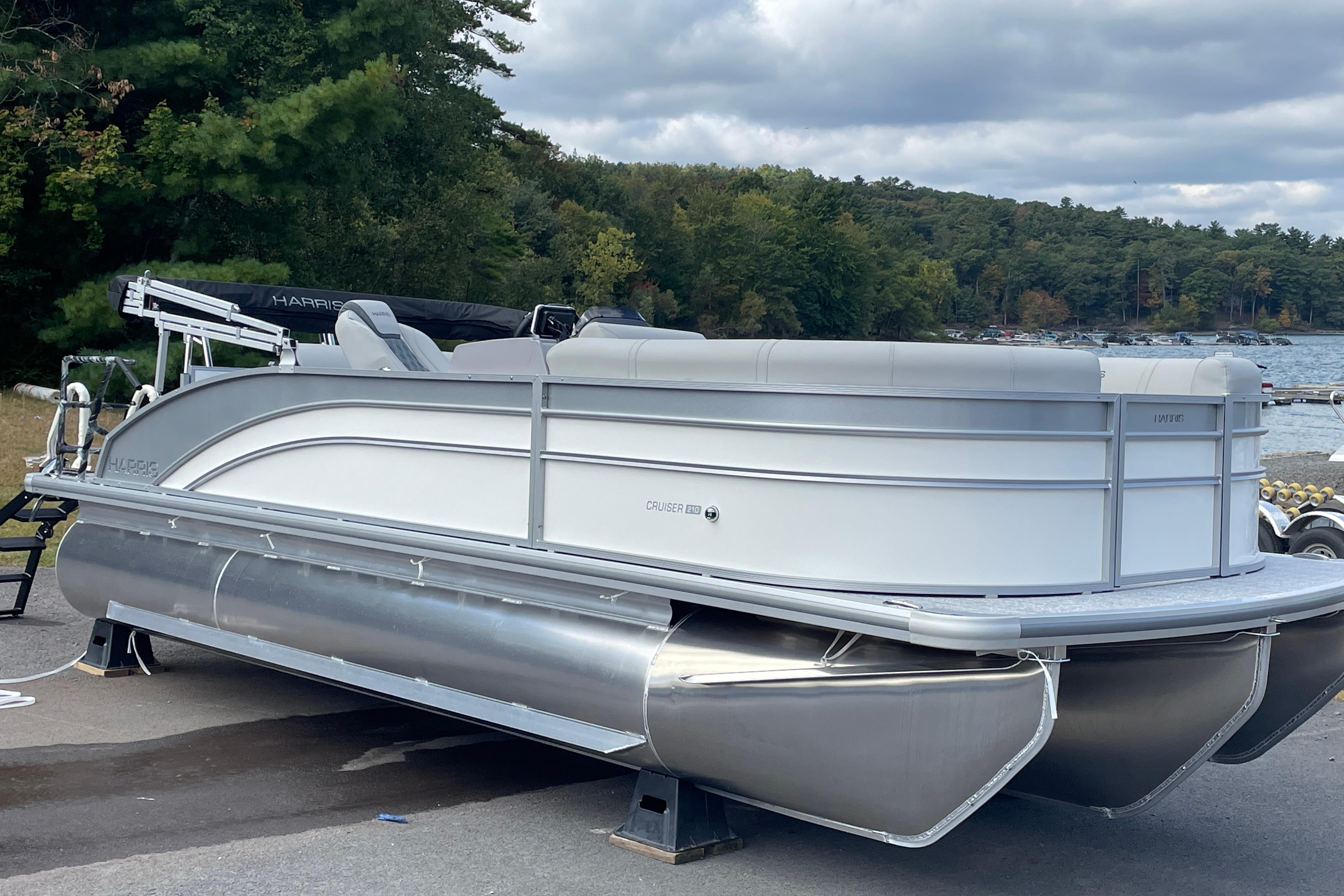Harris FloteBote Cruiser 210 2026 Harris FloteBote Cruiser 210 pontoon boat on display by a scenic lakeside.