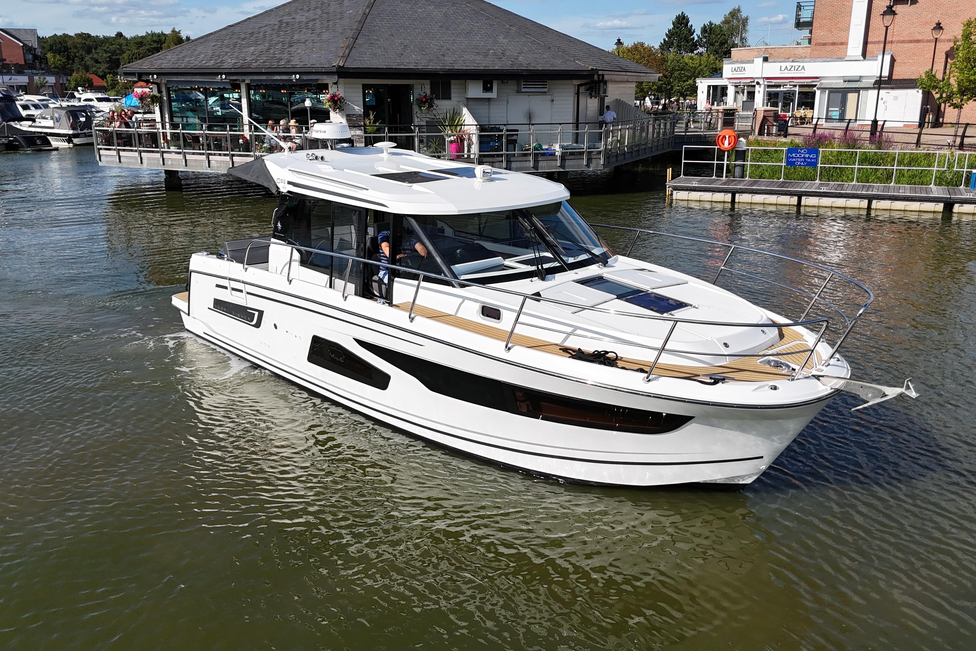 Jeanneau Merry Fisher 1095 2018 Jeanneau Merry Fisher 1095 boat cruising near waterfront buildings.