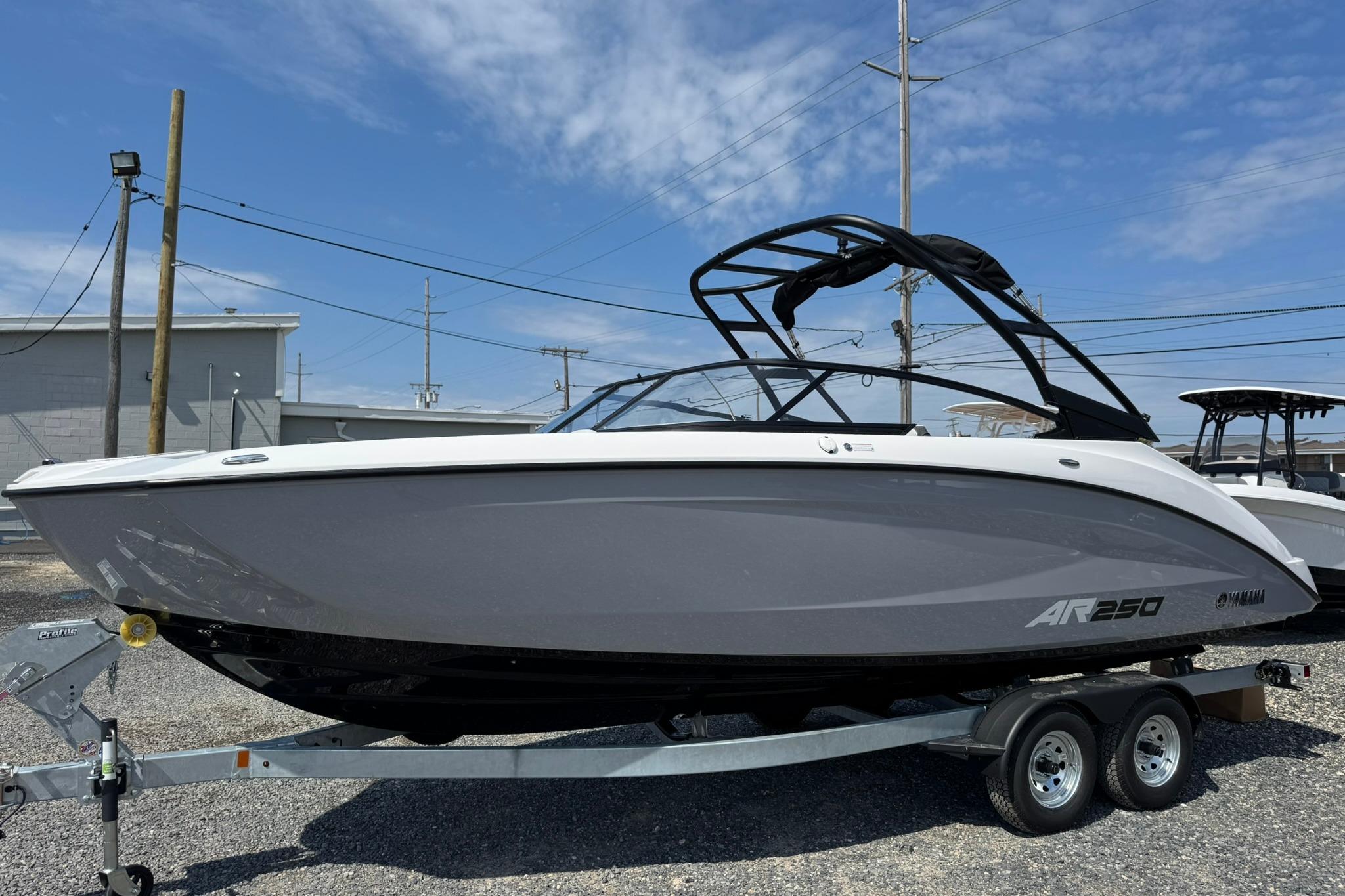 Yamaha Boats AR250 2026 Yamaha Boats AR250 on trailer, sleek design, gray and white exterior, parked outdoors.