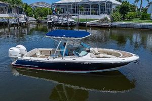 Chris-Craft Calypso 26 2018 Chris-Craft Calypso 26 boat on calm water, featuring a sleek design and blue canopy.