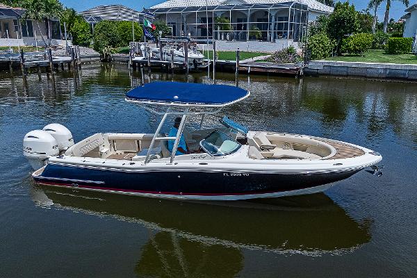 Chris-Craft Calypso 26 2018 Chris-Craft Calypso 26 boat on calm water, featuring a sleek design and blue canopy.