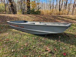 Tracker Grizzly 1036 Utility 2025 Tracker Grizzly 1036 Utility boat on grassy landscape with autumn trees.
