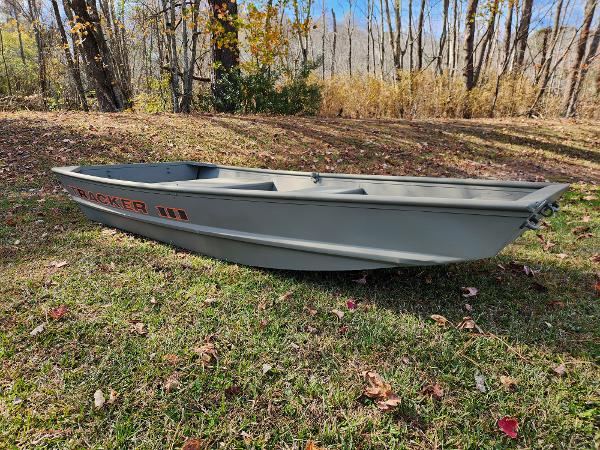 Tracker Grizzly 1036 Utility 2025 Tracker Grizzly 1036 Utility boat on grassy landscape with autumn trees.