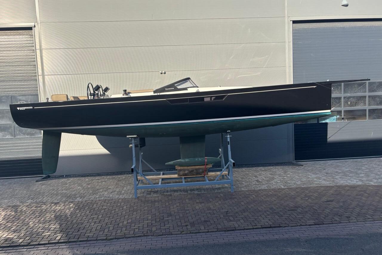Saffier SE 33 Life 2022 Saffier SE 33 Life sailboat on stand, sleek design, black hull, modern marina setting.