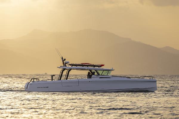 Axopar 45 Cross Top 2025 Axopar 45 Cross Top boat cruising at sunset with mountains in the background.