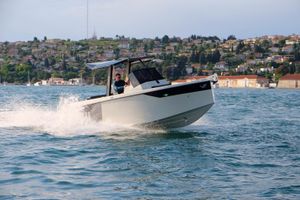 Veloce Yachts V750 2025 Veloce Yachts V750 cruising on water near coastal town.