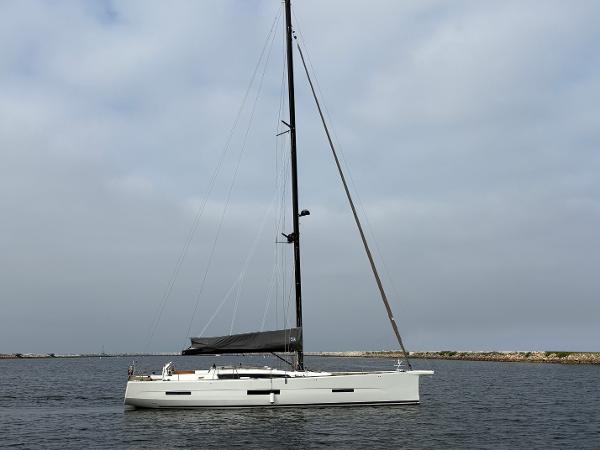 Dufour 560 Exclusive 2018 Dufour 560 Exclusive sailboat on calm water under cloudy sky.