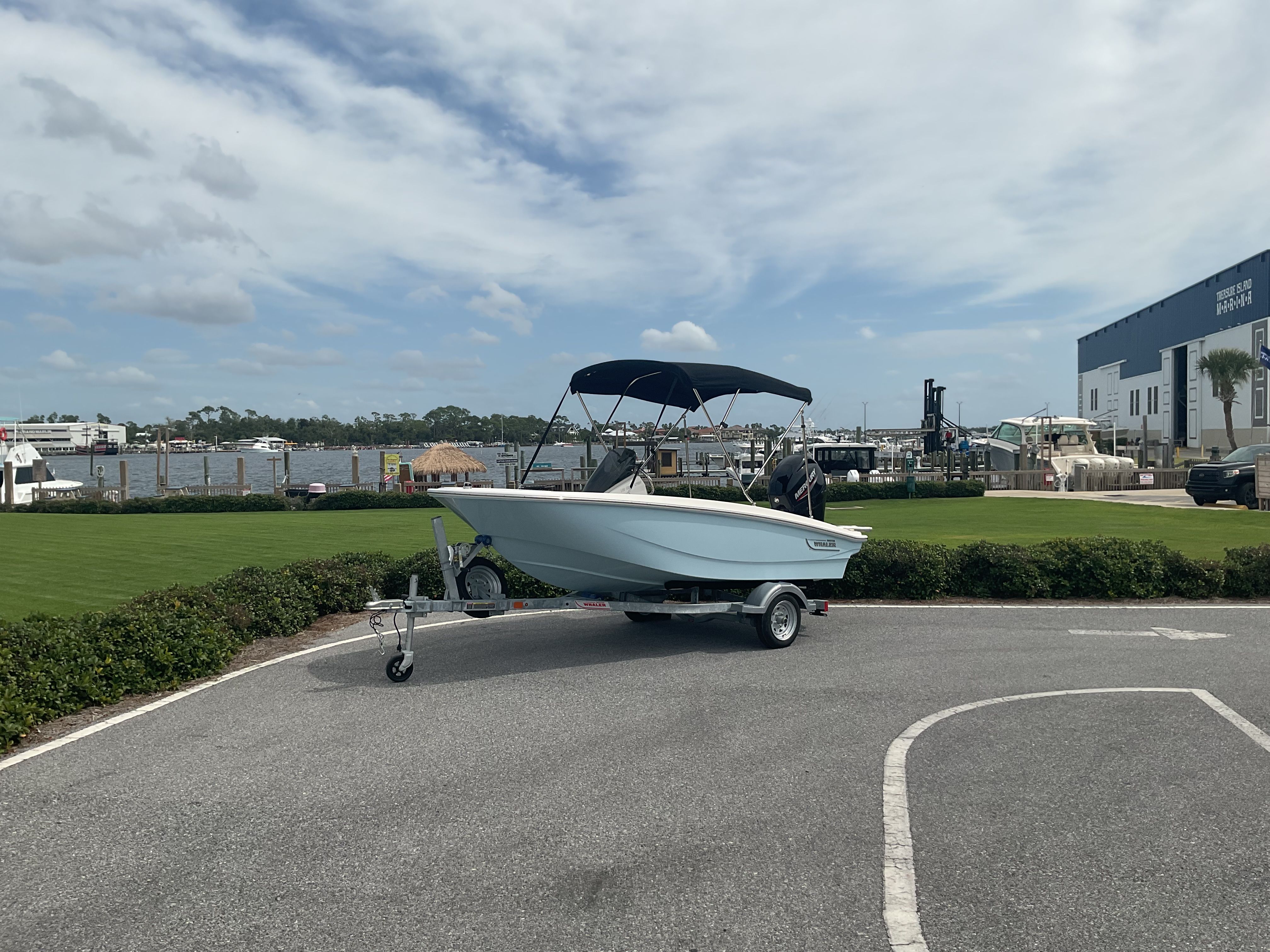 Boston Whaler 13 Super Sport 2024 Boston Whaler 13 Super Sport boat on trailer, parked near marina.