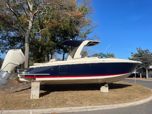 Chris-Craft Launch 28GT 2025 Chris-Craft Launch 28GT boat on display, blue and white hull, parked on blocks.