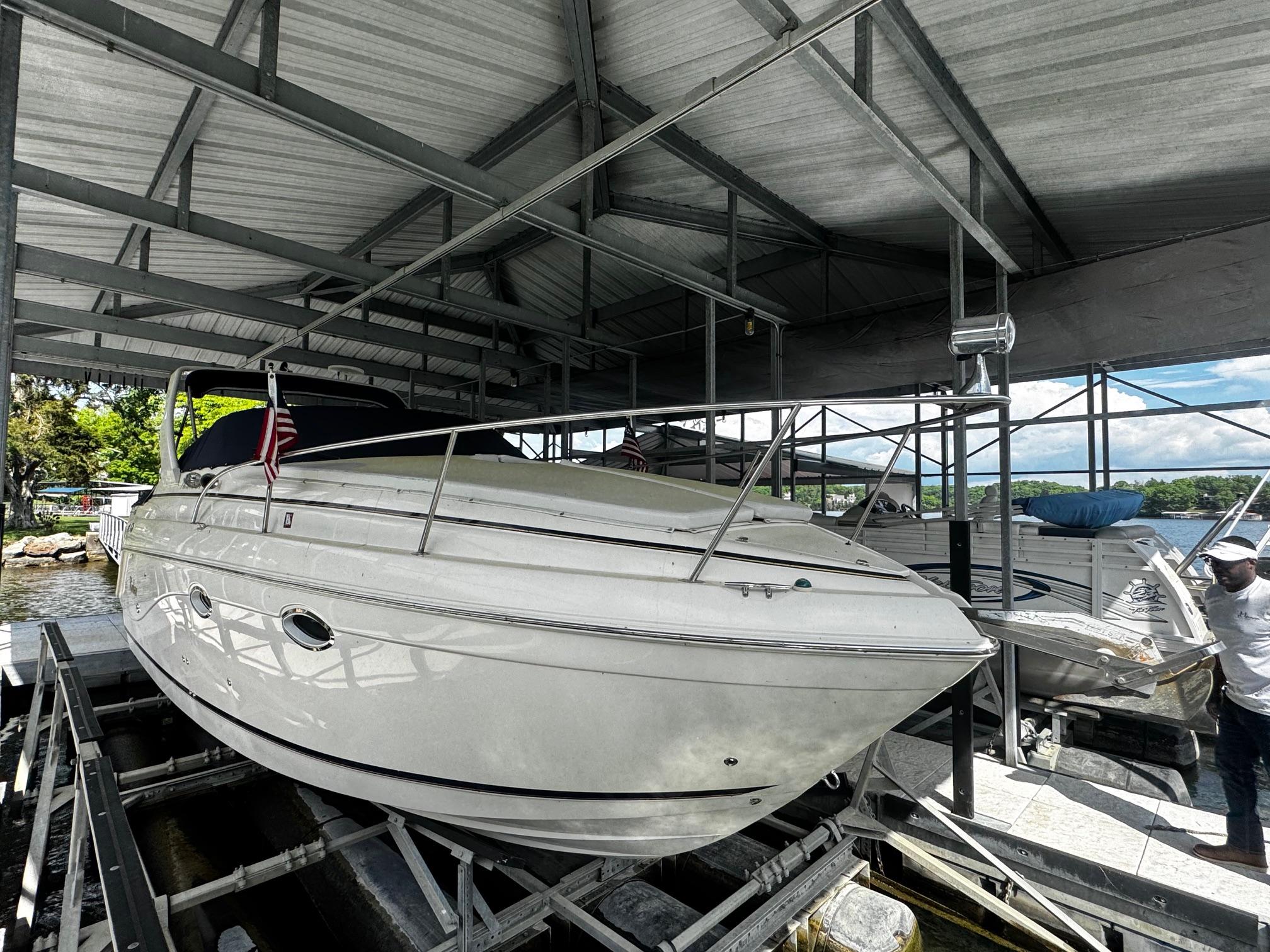 Rinker 270 Epress Cruiser 2003 Rinker 270 Express Cruiser docked under a metal canopy.