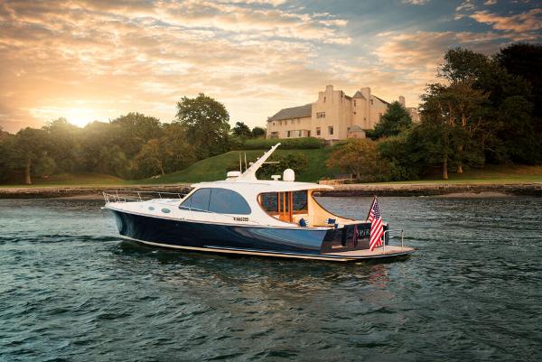 Palm Beach Motor Yachts PB55 2026 Palm Beach Motor Yachts PB55 cruising near a scenic shoreline at sunset.