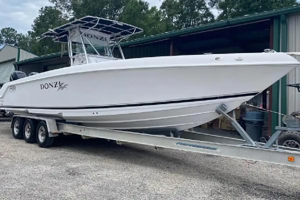 Donzi 32 ZF Open 2006 Donzi 32 ZF Open boat on trailer, parked outdoors near a storage facility.
