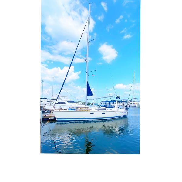 Hunter 430 1997 Hunter 430 sailboat docked at marina under blue sky.