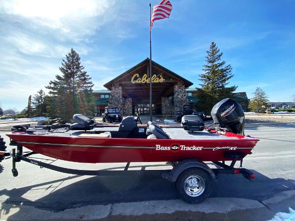 Tracker Bass Tracker Classic XL 2025 Tracker Bass Tracker Classic XL boat outside Cabela's store, under clear blue sky.